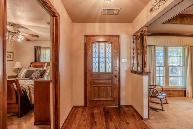 entryway with a textured ceiling, ceiling fan, and hardwood / wood-style floors