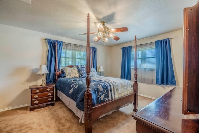 carpeted bedroom featuring ceiling fan and a textured ceiling