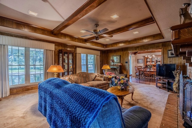 living room featuring ceiling fan, light colored carpet, plenty of natural light, and wooden walls