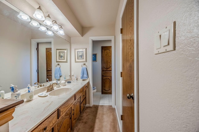 bathroom with toilet, tile patterned floors, and vanity