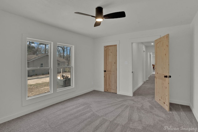 unfurnished room featuring ceiling fan and light carpet