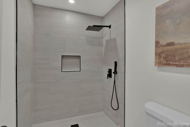 bathroom featuring toilet and tiled shower