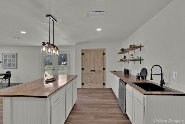 kitchen featuring sink, pendant lighting, wooden counters, and french doors