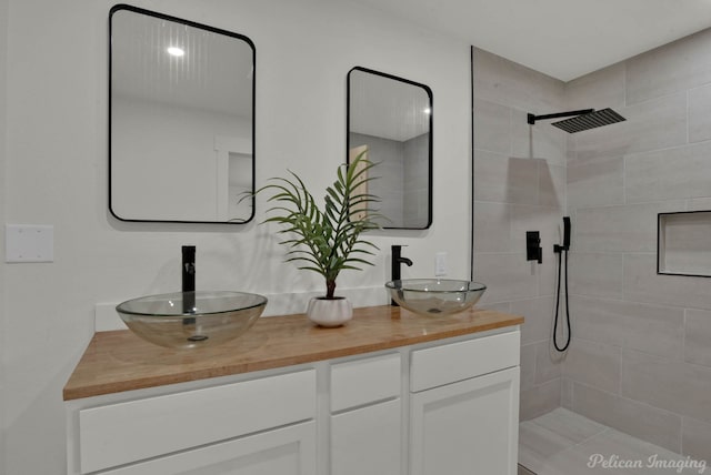 bathroom featuring vanity and tiled shower