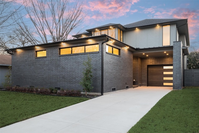 view of front of property with a garage and a yard