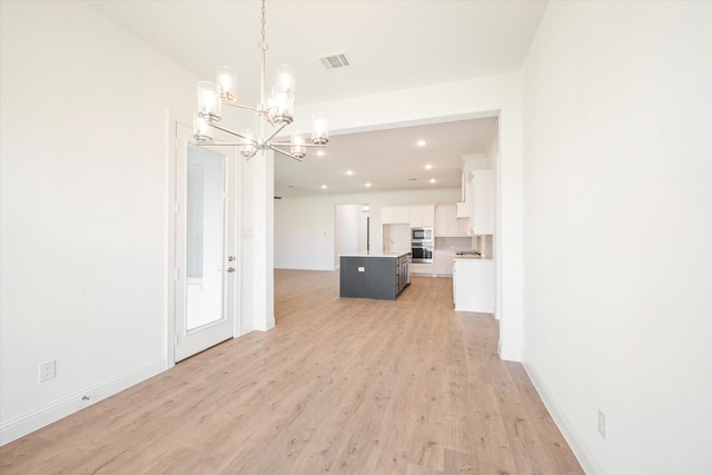 interior space featuring a chandelier and light hardwood / wood-style flooring