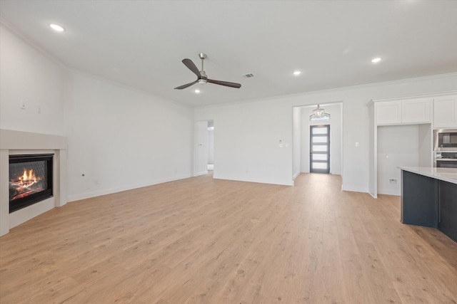 unfurnished living room with ceiling fan, ornamental molding, and light hardwood / wood-style floors