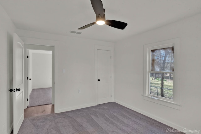 unfurnished bedroom with ceiling fan, light colored carpet, and a closet