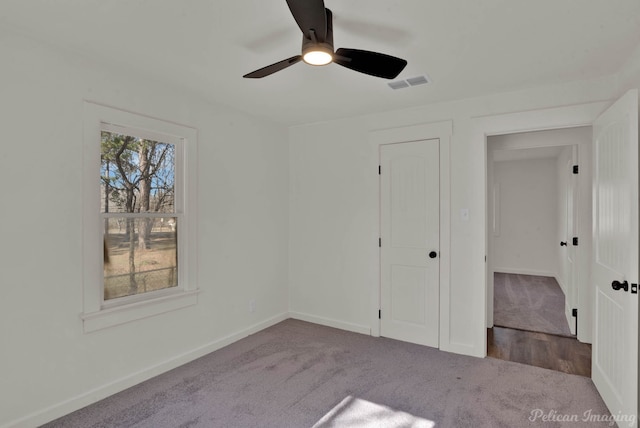 unfurnished bedroom with ceiling fan, light carpet, and a closet