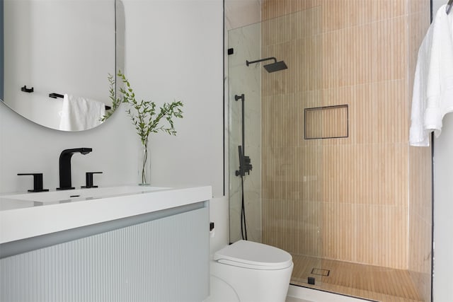 bathroom featuring tiled shower, vanity, and toilet