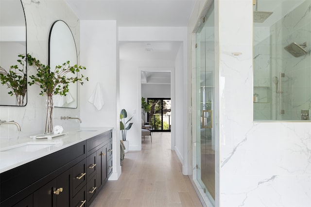 bathroom featuring a shower with shower door, hardwood / wood-style flooring, and vanity