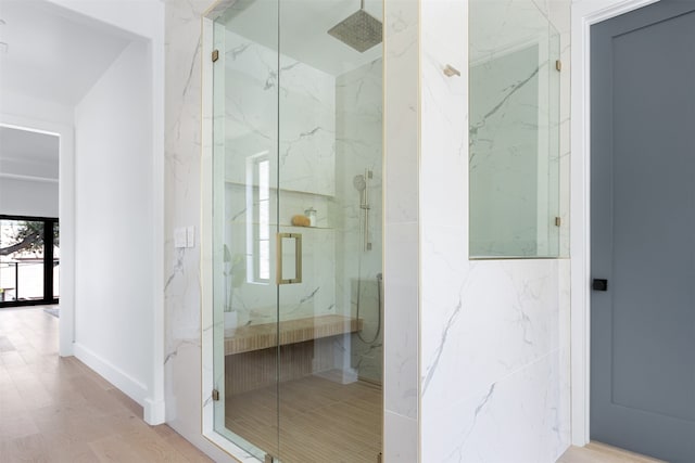 bathroom featuring a shower with shower door and wood-type flooring