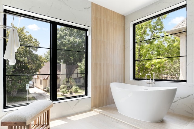 bathroom featuring tile walls and a tub to relax in