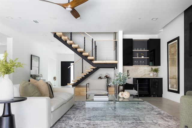 living room with ceiling fan, bar area, and beverage cooler