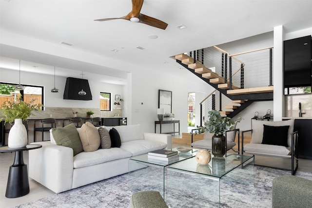 living room featuring ceiling fan and a healthy amount of sunlight