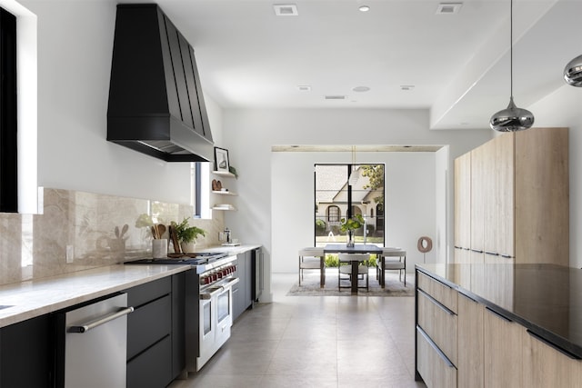 kitchen with pendant lighting, light brown cabinets, stainless steel appliances, decorative backsplash, and custom range hood