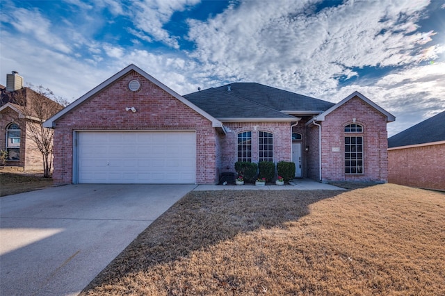 view of front of property with a garage and a front lawn