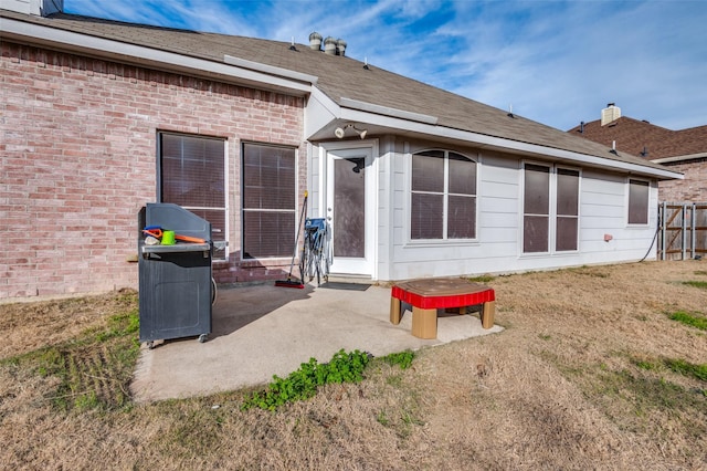 rear view of house featuring a lawn and a patio