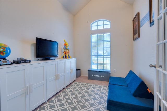 living area featuring lofted ceiling and light carpet