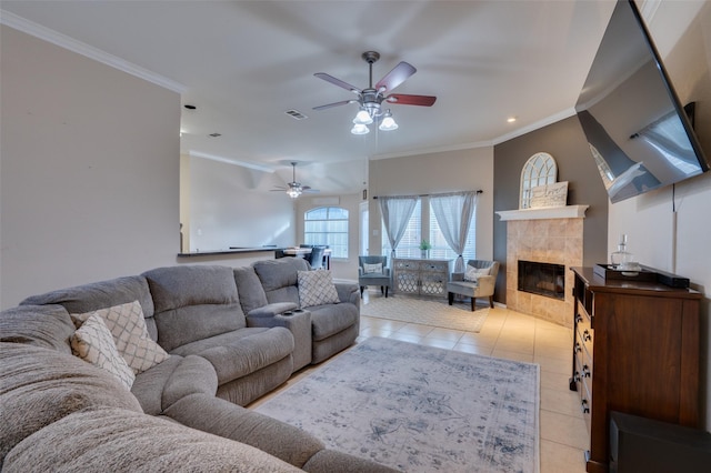 tiled living room featuring ceiling fan, a fireplace, and crown molding