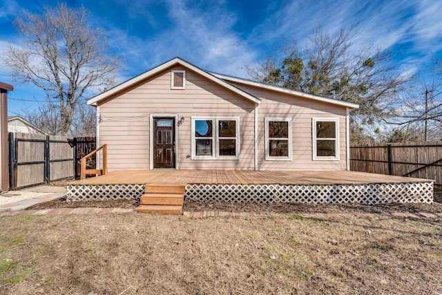 rear view of property with a deck and a yard