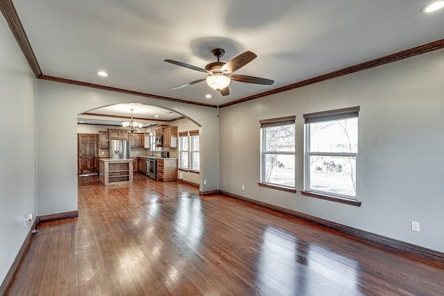 unfurnished living room featuring ceiling fan with notable chandelier, light hardwood / wood-style floors, and crown molding