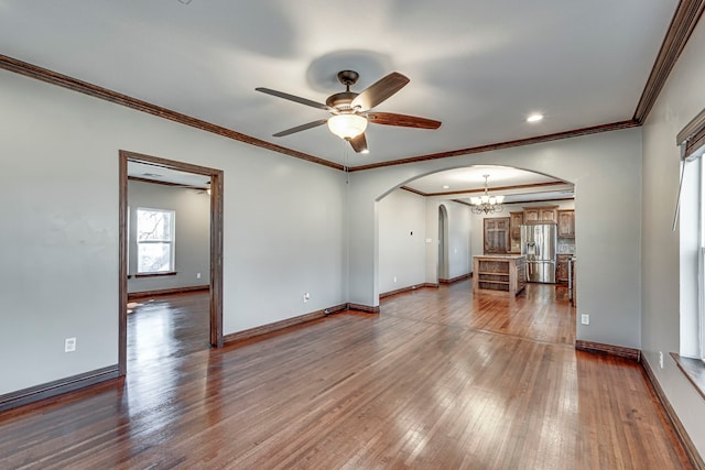 unfurnished living room with ceiling fan, wood-type flooring, and ornamental molding