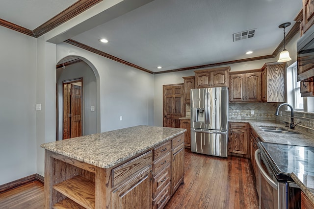 kitchen with dark hardwood / wood-style floors, a center island, decorative backsplash, sink, and appliances with stainless steel finishes