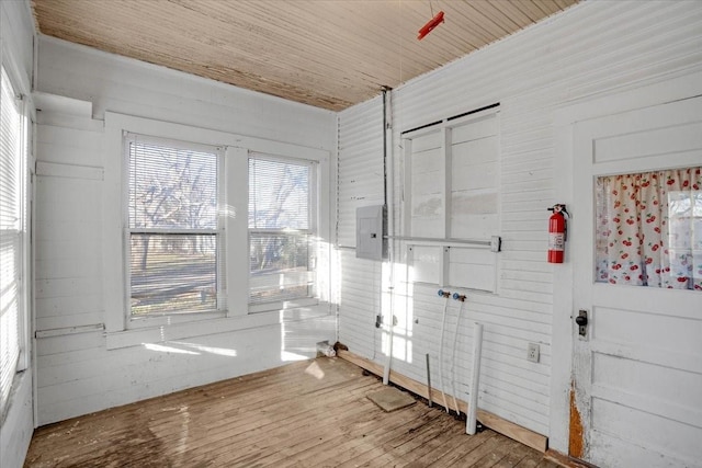 spare room featuring light hardwood / wood-style flooring, wooden walls, and wooden ceiling