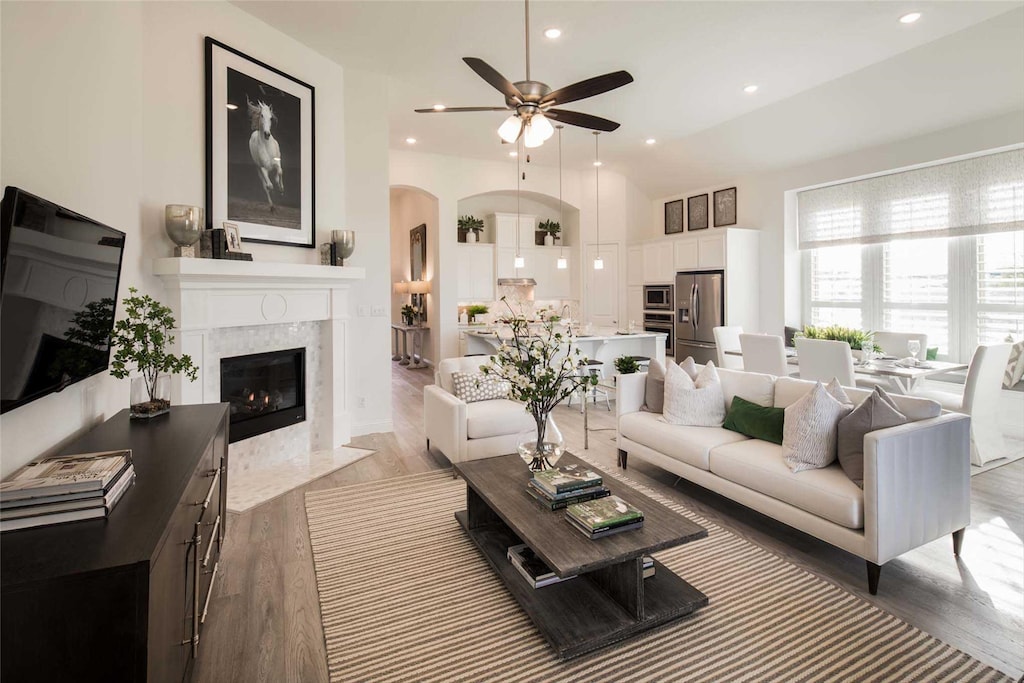 living room featuring ceiling fan, a fireplace, and hardwood / wood-style floors