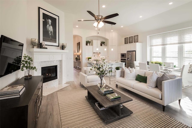 living room featuring ceiling fan, a fireplace, and hardwood / wood-style floors