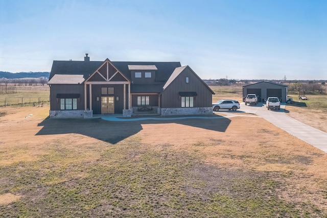 modern inspired farmhouse with an outbuilding, a rural view, covered porch, and a garage