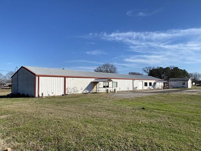 view of front of house with an outdoor structure and a front yard