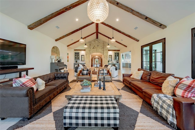 living room with ceiling fan with notable chandelier, carpet, beam ceiling, and high vaulted ceiling