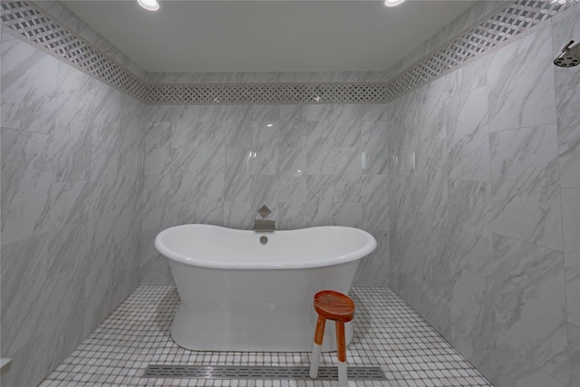 bathroom featuring tile patterned flooring, tile walls, and a bathing tub