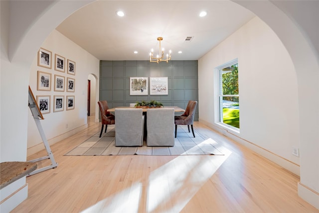 dining area featuring an inviting chandelier and light hardwood / wood-style flooring