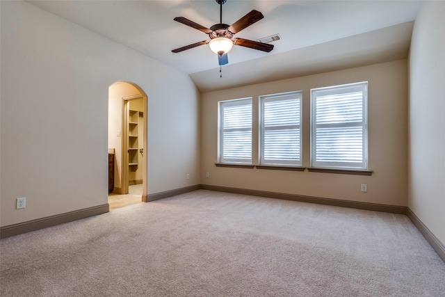 empty room with ceiling fan, light colored carpet, and lofted ceiling