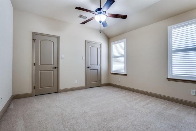 unfurnished bedroom with ceiling fan, light carpet, and lofted ceiling