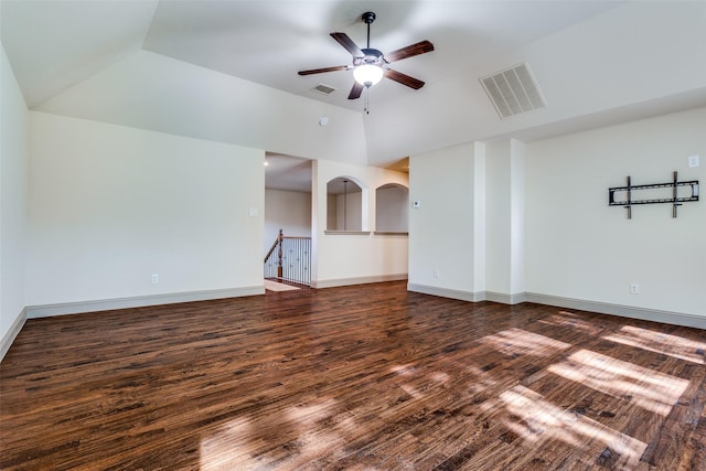 unfurnished living room with ceiling fan, vaulted ceiling, dark hardwood / wood-style floors, and a raised ceiling