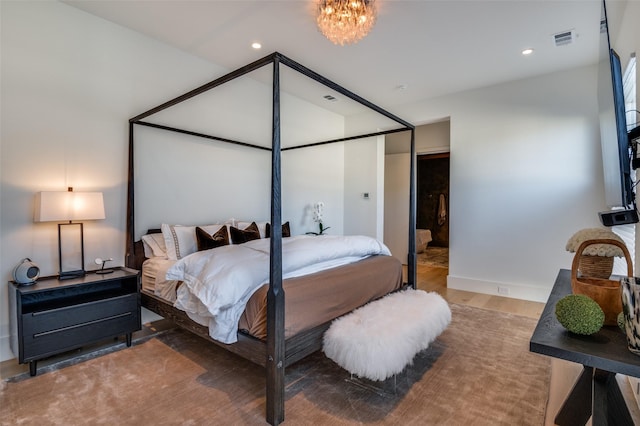 bedroom featuring an inviting chandelier and hardwood / wood-style flooring