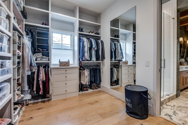 walk in closet with light hardwood / wood-style floors