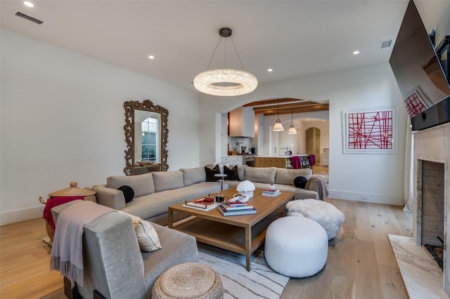 living room featuring a brick fireplace and light hardwood / wood-style floors