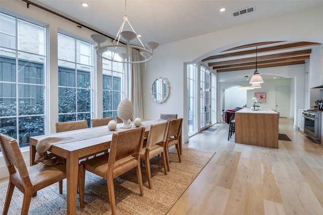 dining space featuring sink, french doors, beamed ceiling, and light wood-type flooring