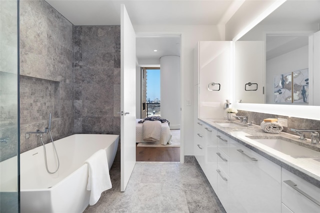 bathroom with vanity, tile walls, and a tub