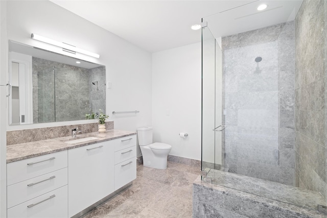 bathroom featuring a shower with shower door, vanity, and toilet