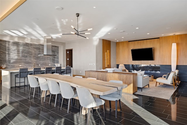 dining area with a notable chandelier and wooden walls