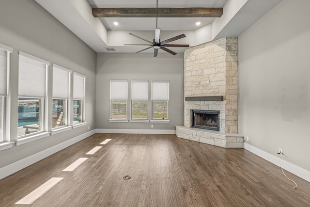 unfurnished living room with ceiling fan, a fireplace, hardwood / wood-style flooring, and beamed ceiling