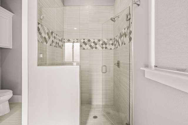 bathroom featuring walk in shower and toilet