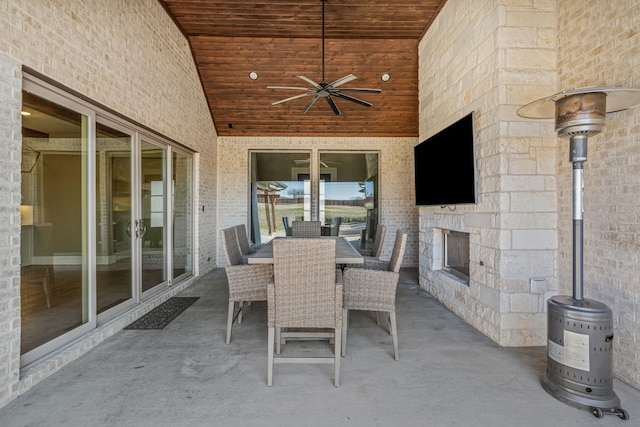 view of patio / terrace featuring ceiling fan and an outdoor stone fireplace