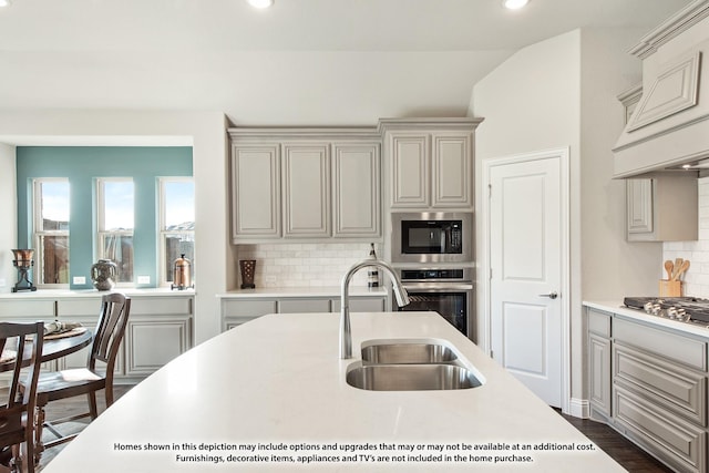 kitchen featuring tasteful backsplash, vaulted ceiling, sink, and stainless steel appliances